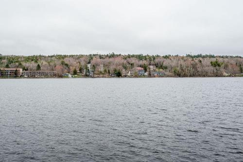 a large body of water with buildings in the background at The Tranquil lake-house at Fletchers Lake in Fall River