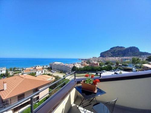 a balcony with a view of the ocean at Holidays Cefalù Rooms in Cefalù
