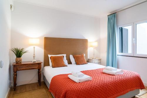 a bedroom with a bed with two towels on it at Vila da Falésia-With Pool and views in Caniço