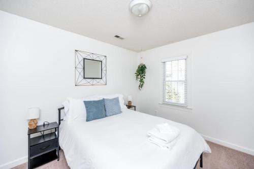 a white bedroom with a large bed and a window at Arcade Private Sauna Large Yard in Apex
