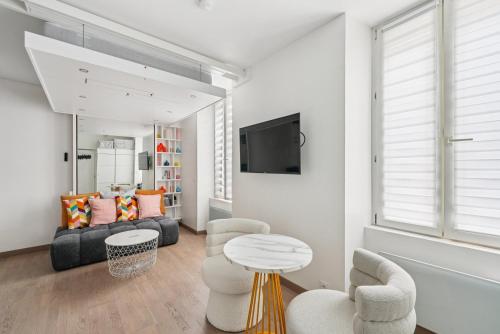 un salon avec un canapé, une table et des chaises dans l'établissement Le Haute Couture, à Paris