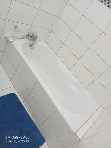 a bath tub with a faucet in a bathroom at Emlomo logde in Ermelo