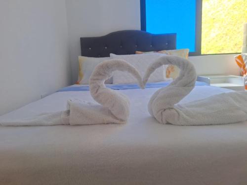 two towels are made to look like swans on a bed at CASA BLANCA EN LA VEGA in La Vega