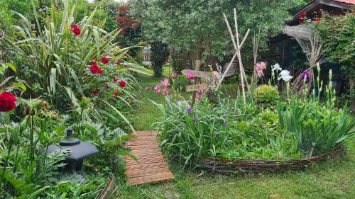 a garden with a wooden path and flowers at Le chalet du Jardin caché in Marmande