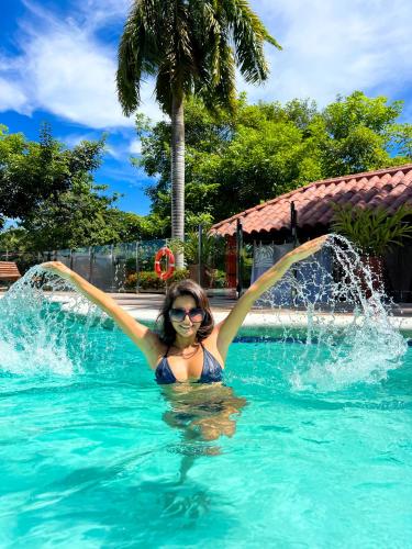 a woman in a swimming pool with a fountain at Senderos del Mar - Tayrona in Buritaca