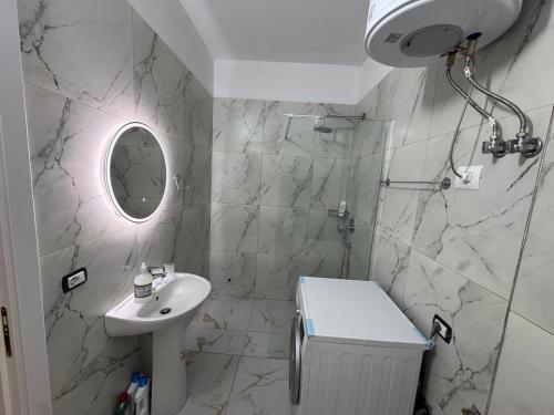 a white bathroom with a sink and a mirror at Flat in Orikum Beach in Orikum