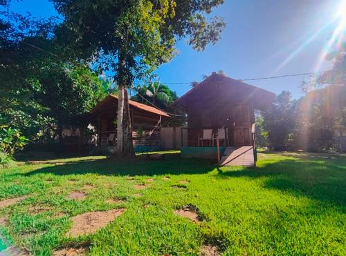 a house with a tree in the yard at Pousada AldeiA Cotijuba in Belém