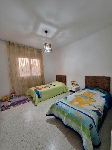 a bedroom with two beds and a window at emplacement exceptionnel in Tunis
