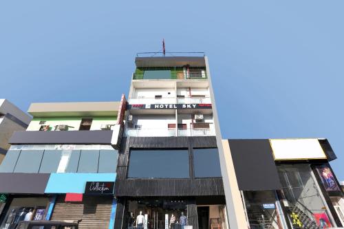 a tall white building with a lot of windows at Hotel O Sky Hotel in Rohtak