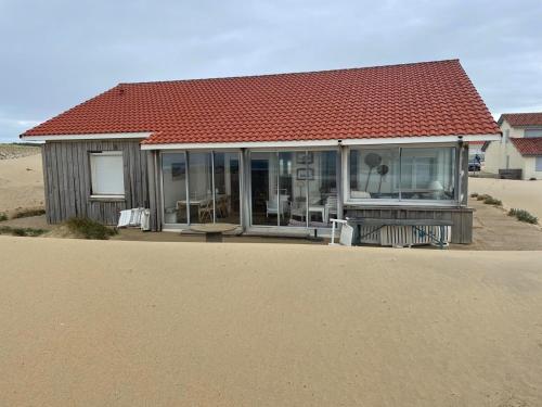 une maison avec un toit rouge dans le désert dans l'établissement Beach front House, à Vielle-Saint-Girons
