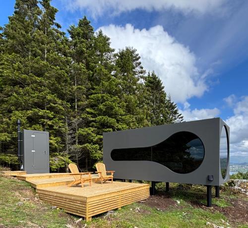 a house with a large window on a wooden deck at Birdbox Bergen in Bergen