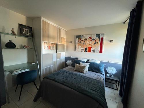 une chambre avec un lit et une chaise dedans dans l'établissement TRES BEL APPARTEMENT Ploumanac'h Centre, à Perros-Guirec