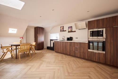 une cuisine avec des placards en bois et une table avec une salle à manger dans l'établissement L Ecrin des Minimes, au Mans