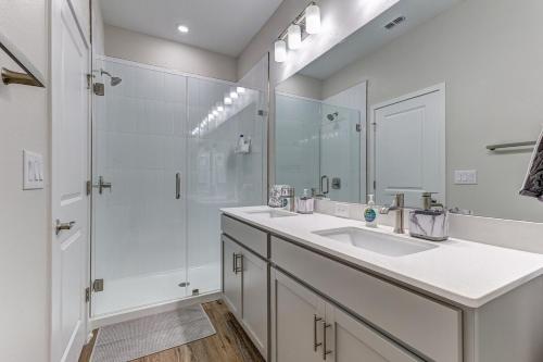 a white bathroom with two sinks and a shower at 3 Bedroom 4 Bathroom House Tampa Sleeps 10 Private Garage Near Stadium in Tampa