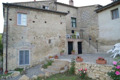 an old stone building with a patio in front of it at Agriturismo Le Cantine in Poggibonsi