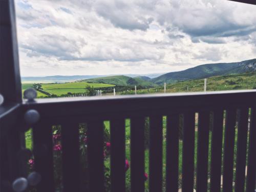 a balcony with a view of the hills and mountains at La Ograda - Cheile Turzii, near Turda in Sănduleşti