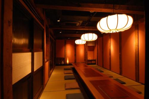 a row of tables in a room with lights at かっぱの宿旅館三治郎 in Zao
