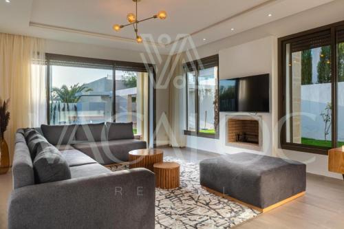 un soggiorno con divano e camino di Houd Taghazout - luxury villa - Pool - 6 or 7 Px a Taghazout