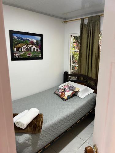a small bed in a room with a window at Alojamiento típico Calarca in Calarcá