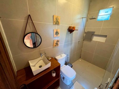 a bathroom with a sink and a toilet and a mirror at Pousada AldeiA Cotijuba in Belém