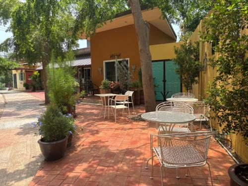 a patio with tables and chairs on a brick sidewalk at Kireeya Villa in Phetchaburi