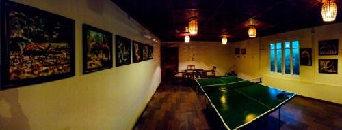 a room with a ping pong table and pictures on the wall at Blackberry Hills Munnar Nature Resort & Spa in Munnar