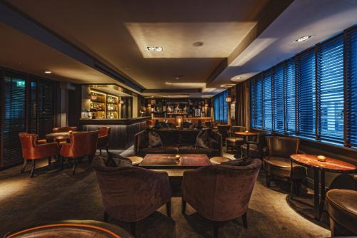 a bar with couches and tables and chairs at Dakota Glasgow in Glasgow