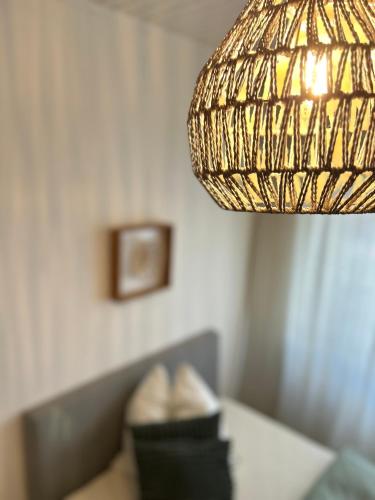 a lamp hanging over a couch with a pillow at City Apartment Nähe Uni mit Parkplatz in Koblenz