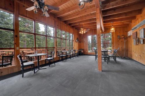 a dining room with tables and chairs and windows at Kit Carson Lodge in Kit Carson