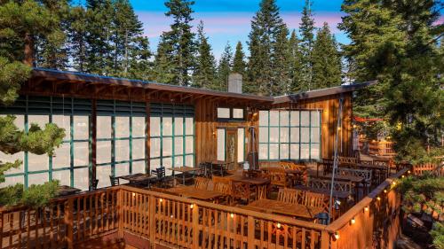 a house with a deck with tables and chairs at Kit Carson Lodge in Kit Carson
