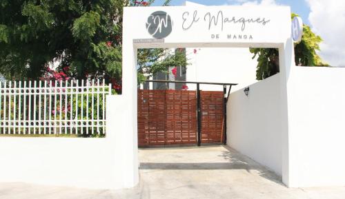 an entrance to a white gate with a white fence at Hotel El Marqués De Manga in Cartagena de Indias