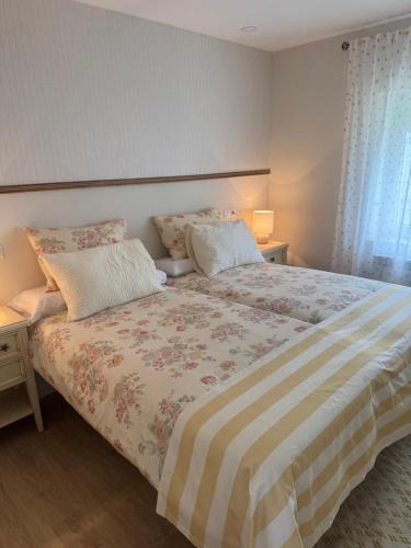 a bedroom with a large bed with two pillows at Apartamento La Sabina in Reinosa
