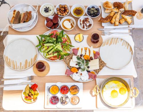 a table with many plates of food on it at Boii Rest & Breakfast in Siğacık