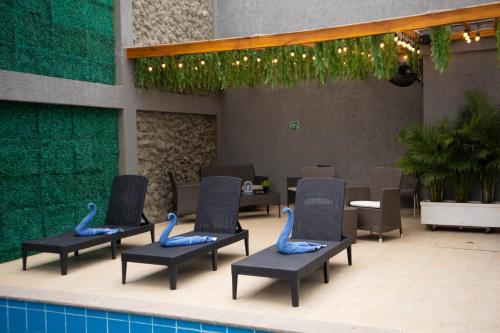 a group of chairs sitting next to a swimming pool at Hotel El Marqués De Manga in Cartagena de Indias
