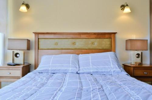 a bed with two white pillows and two lamps at Hermoso Departamento Primera Linea de Concon in Concón
