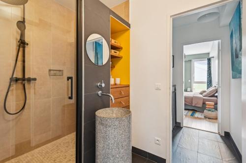 La salle de bains est pourvue d'une douche et d'une porte menant à une chambre. dans l'établissement Duplex design relaxing garden Porte de Paris, à Bagnolet