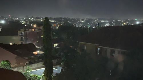 a view of a city at night with lights at Keaden-homes in Kampala