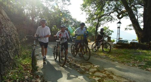 a group of people riding bikes on a trail at Blackberry Hills Munnar Nature Resort & Spa in Munnar