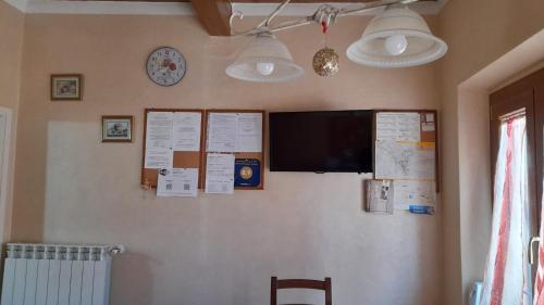a wall with a television and a clock on it at Appartamenti Roberta Cisanello in Pisa