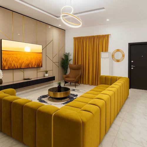 a living room with a large yellow couch and a tv at DPK Estate Cozy Room in Lekki