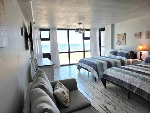 a living room with two beds and a couch at Fabulous Oceanfront Studio w/kitchen, tiki bar in Daytona Beach