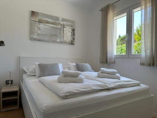 a large white bed with two pillows on it at Holiday House Laura in Vir