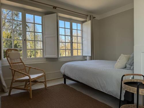 une chambre avec un lit, une chaise et des fenêtres dans l'établissement L'APPART enTHÈSE - Appartement pour une ou deux pers - Accessible à Tous - Meuble Tourisme 3 étoiles en BOURGOGNE, à Moloy