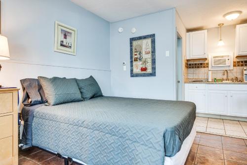 a blue bedroom with a bed and a kitchen at Walk to Old Orchard Pier Cozy Beachfront Condo! in Old Orchard Beach