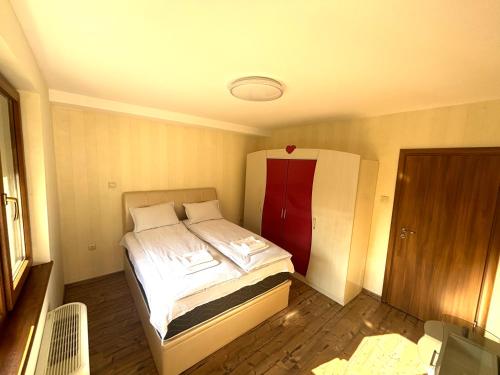 a small bedroom with a bed with a red door at Villa Amity in Varna City