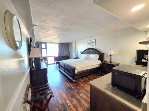 una habitación de hotel con una cama y un televisor en Beachfront Studio fit for a King, en Daytona Beach