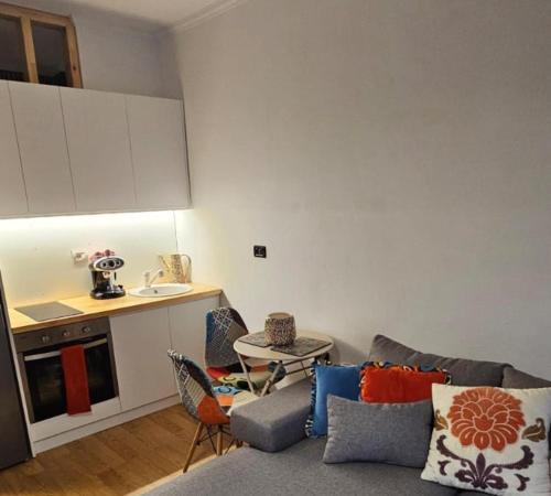 a living room with a couch and a kitchen at Ilia's Coastal Apartement in Vlorë