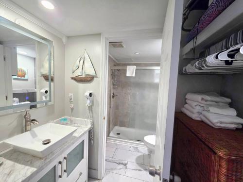 Un baño con lavabo, inodoro y ducha. en Sunrise Oceanfront 2 Full Studio w/kitchen & pool, en Daytona Beach