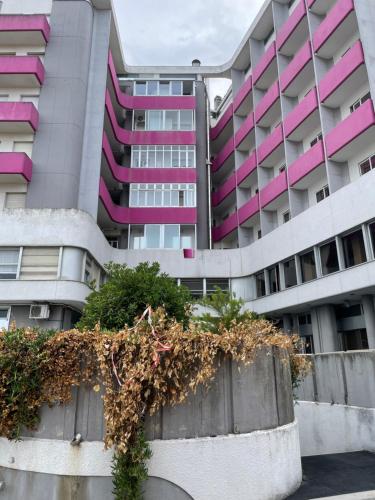 un immeuble d'appartements avec du rose et du violet dans l'établissement Camera Smeraldo, à Senigallia