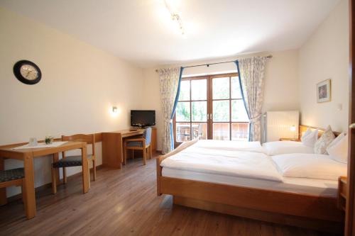 een slaapkamer met een bed, een bureau en een raam bij Ferienwohnungen Kirschner in Bad Birnbach